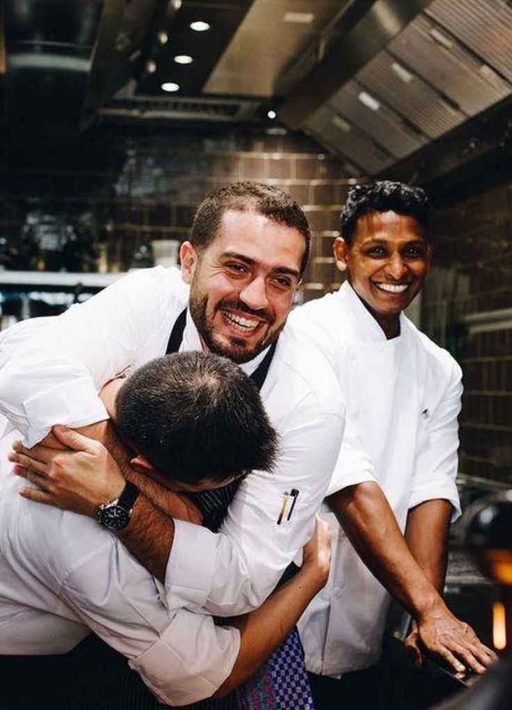 Cuochi che ridono e si abbracciano in cucina a fine servizio